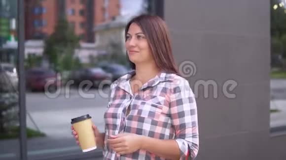 一个穿着裙子的漂亮女孩带着包裹去购物手里拿着一杯咖啡喝得很好视频的预览图