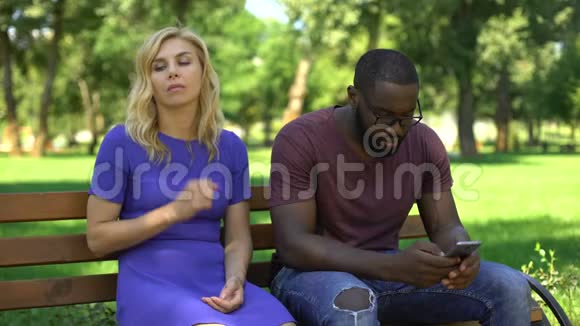 美国黑人男子在公园玩手机无视悲伤的女友视频的预览图