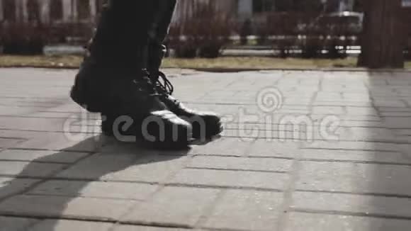 男人的双腿穿着靴子沿着城市大街走视频的预览图