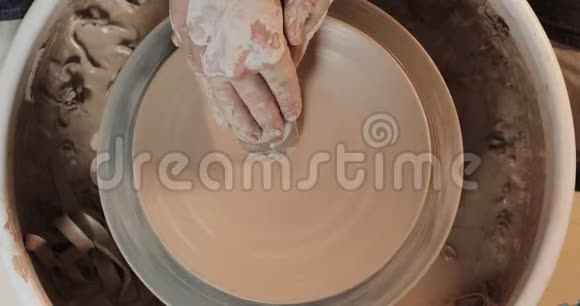 双手用专业工具在陶轮上工作在粘土板上形成浮雕上景波特在工作视频的预览图