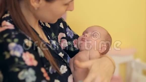 快乐的年轻母亲握着她婴儿的手婴儿因晕车而打哈欠视频的预览图