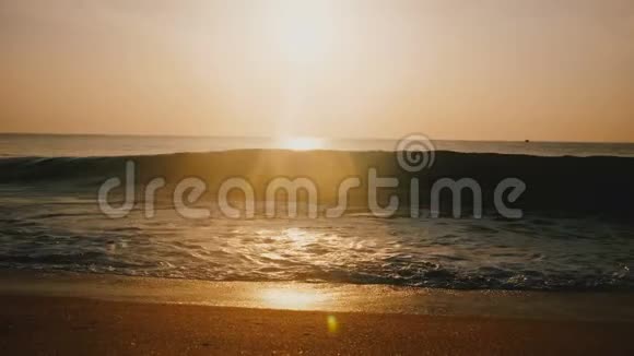 美丽的背景镜头耀斑拍摄的田园金色日落在惊人的海洋度假海滩大浪即将到来视频的预览图
