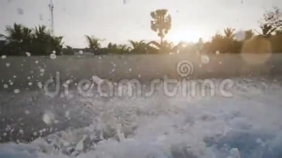我的特写背景拍摄泡沫白色海浪飞溅在异国情调的日落海滩与惊人的棕榈树视频的预览图