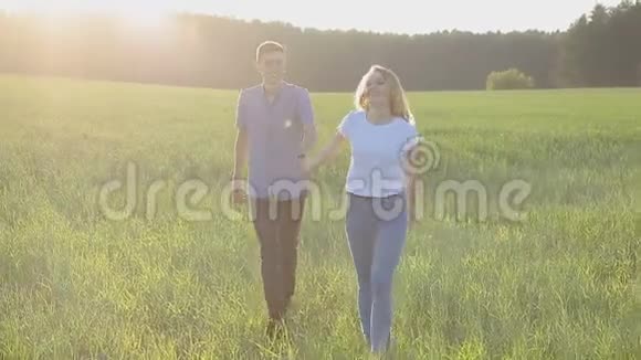 一男一女正牵着手走在草地上视频的预览图