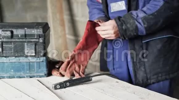 在工作服上盖好焊工戴上红色手套视频的预览图