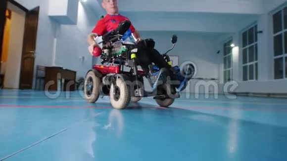 坐轮椅的残疾人扔红色的小球大体育馆视频的预览图