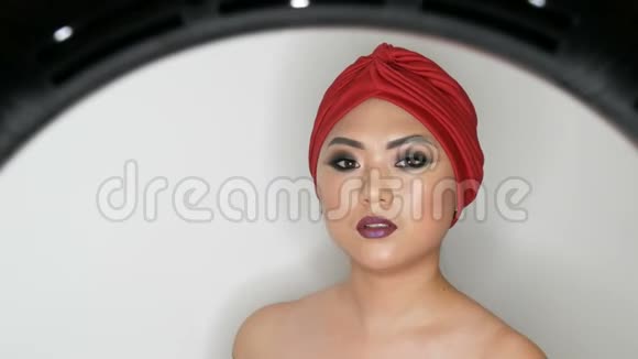 高级时尚一位美丽的亚洲女孩模特的肖像她身着红色头巾身着鲜艳的化妆视频的预览图