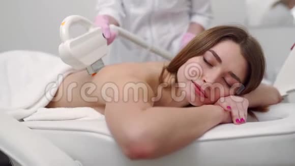 年轻漂亮的微笑女人在美容院的激光脱毛做elos脱毛治疗的美容师视频的预览图