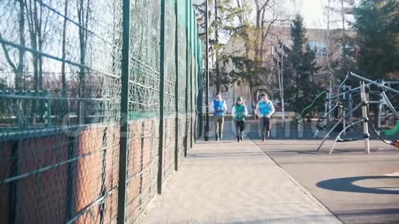 快乐的年轻人在深秋公园跑步慢动作视频的预览图