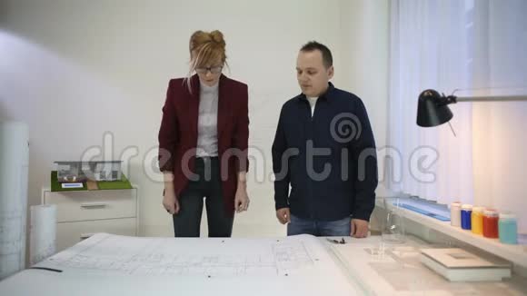两位建筑师在桌子上观看增强现实投影视频的预览图