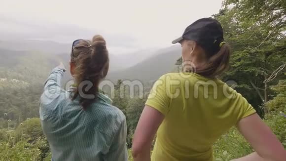 两个女人站在山峰上望着青山和森林视频的预览图