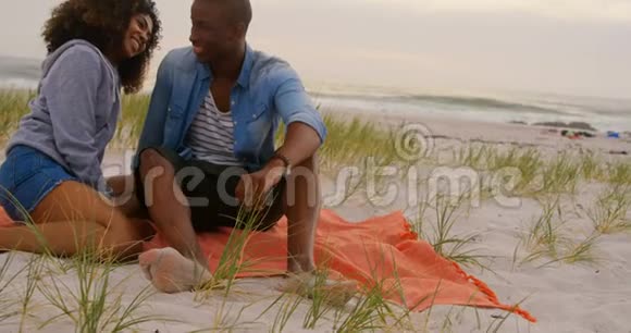非裔美国人夫妇在海滩上相互交流的正面景色视频的预览图