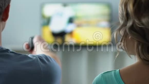 不满的女人和丈夫在电视上看足球吵架冲突视频的预览图