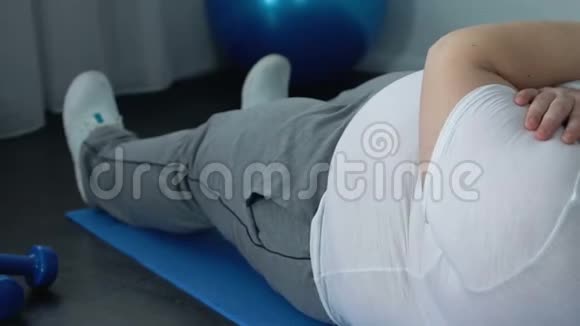 肥胖的男人几乎不做仰卧起坐超重问题身体肌肉无力力量视频的预览图