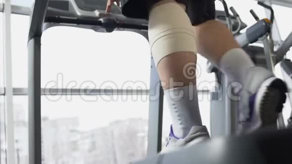 有伤腿肌肉的男性在健身房跑步机上行走恢复后会有动力视频的预览图