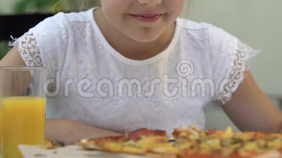 小女孩闻着比萨饼和微笑吃垃圾食品不健康的营养视频的预览图