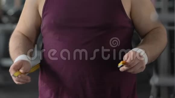 肥胖男子用黄胶带测量腹部锻炼无效超重视频的预览图