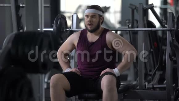 有目的的肥胖男子在健身房举起杠铃推荐锻炼计划健康视频的预览图