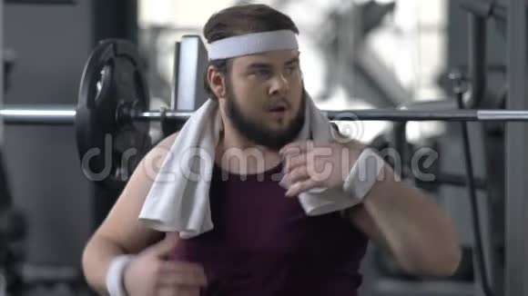健身房里的滑稽胖子假装肌肉强壮吸引了人们的注意视频的预览图