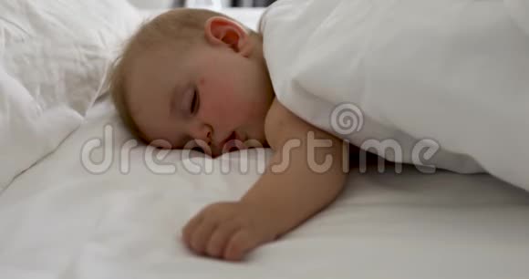 可爱的睡觉宝宝在白色床上视频的预览图