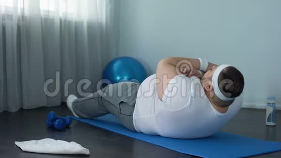肥胖男性运动腹部耐力训练在家垫上仰卧起坐视频的预览图