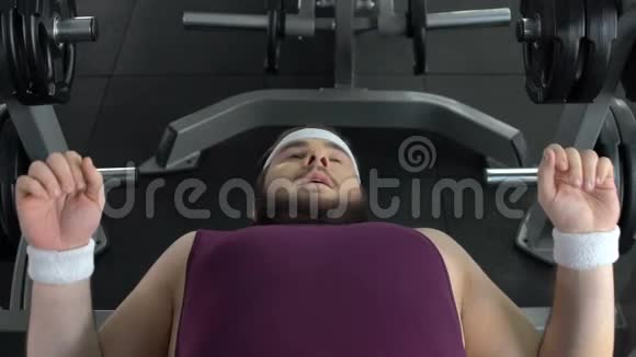 胖子躺在健身房提杠铃运动锻炼减肥视频的预览图