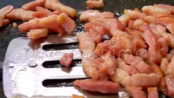 金属刮刀使烤架上的腊肉切丁视频的预览图