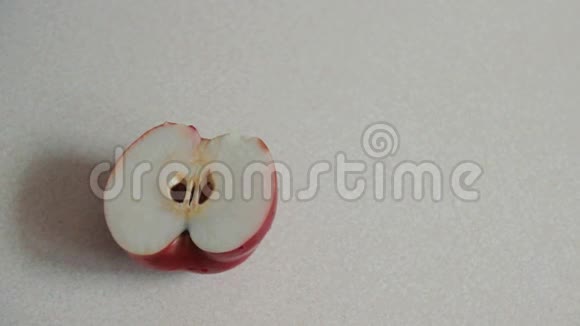 雄性的手把半个苹果切成碎片清理中间的坑一个人把红苹果分成两部分视频的预览图