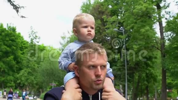 小可爱的宝宝坐在爸爸脖子上公园爸爸天视频的预览图