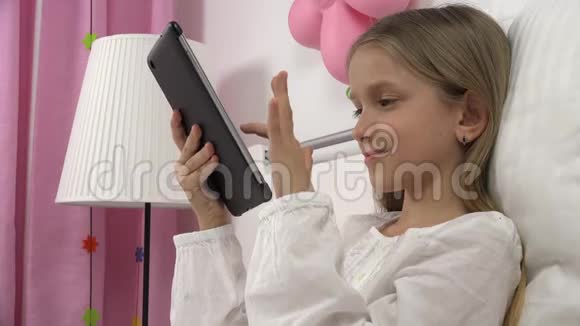 儿童在床上玩平板电脑女孩肖像放松在电脑而不是睡觉的孩子4K视频的预览图