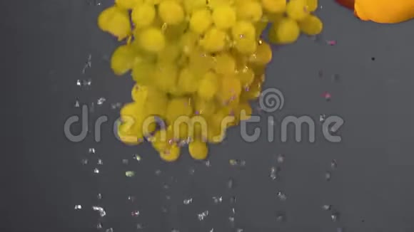 一串绿色的葡萄慢慢地落入水中气泡不断水中的绿葡萄灰色的浆果视频的预览图