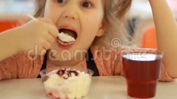 一个孩子在咖啡馆里吃甜点和喝果汁的肖像特写宝宝吃冰淇淋视频的预览图