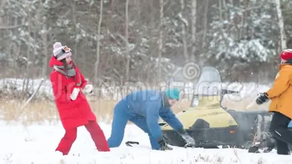 一家人在冬天森林里一辆雪车附近的雪地里玩耍视频的预览图