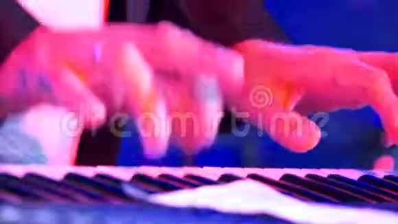 在闪烁的彩灯包围下用电动钢琴弹奏特写男性双手视频的预览图