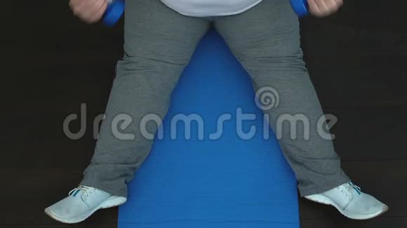 疲惫的肥胖男性训练与哑铃顶部等待锻炼结果视频的预览图