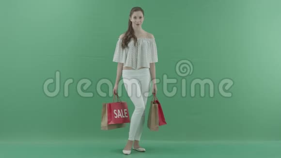 戴着绿色屏幕包摆姿势的快乐女人视频的预览图