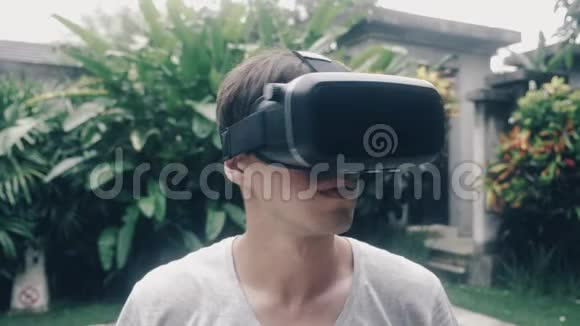 在花园里一位年轻人在户外使用虚拟现实眼镜视频的预览图