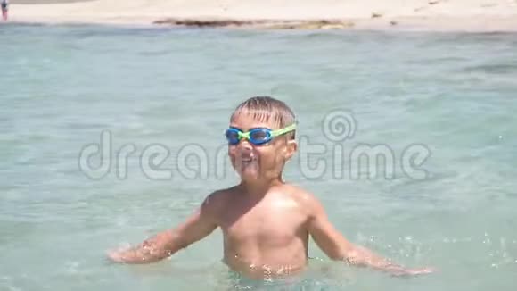 快乐的小男孩在户外的水里玩夏日的乐趣慢动作视频的预览图