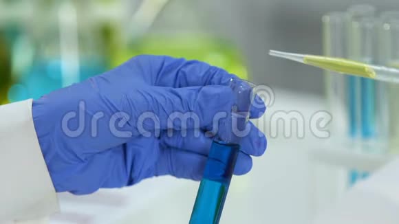 实验室研究人员用蓝色物质在试管中加入绿色液体反应视频的预览图