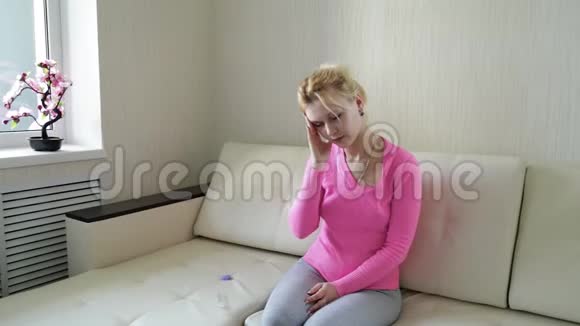 一个疲惫的女人一个棕色长发的女人用电子温度计测量温度女人感冒或视频的预览图