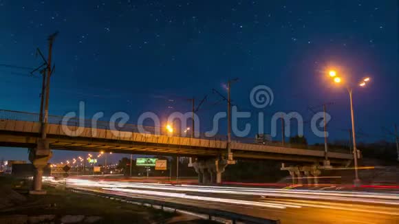 令人惊叹的夜晚城市景观铁路金属桥和道路与星空时间流逝视频的预览图