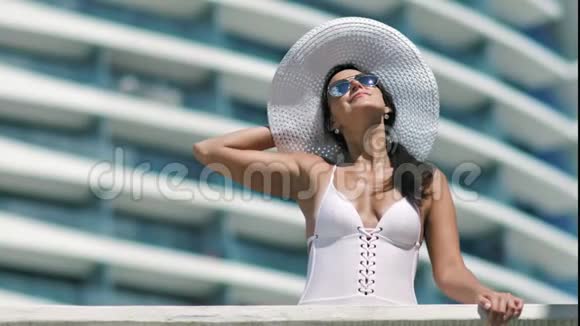 在现代豪华酒店阳台享受日光浴假日的女性享受美好时光视频的预览图