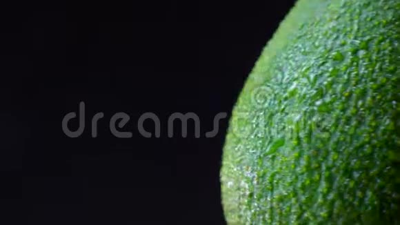 绿色鳄梨的左边部分在黑色背景上逆时针旋转的特写插图视频的预览图