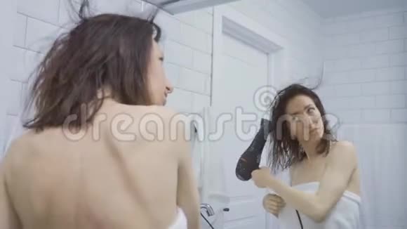 年轻快乐的女人在浴室吹干头发生活方式发型美观视频的预览图