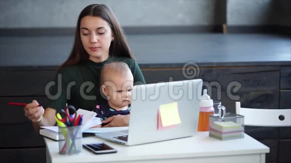 勤劳的女人正在办公室里和她的孩子做笔记视频的预览图