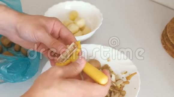 男人手在用黄色的剥皮机剥土豆视频的预览图