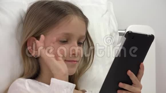 儿童脸在床上玩平板电脑女孩在卧室放松不睡4K视频的预览图