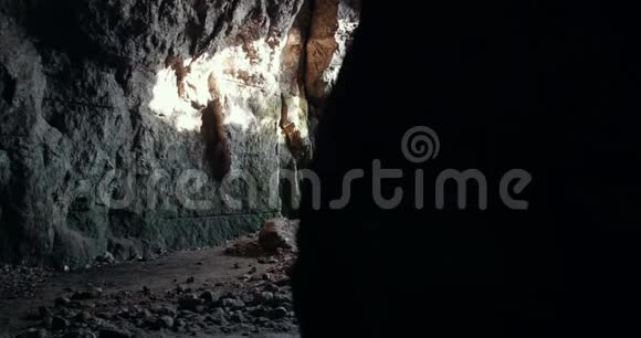 一群戴着头盔的年轻物种学家进入黑暗的洞穴视频的预览图