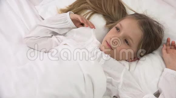 睡在床上的悲伤体贴的孩子不睡觉在卧室里睡一张可爱的女孩脸视频的预览图