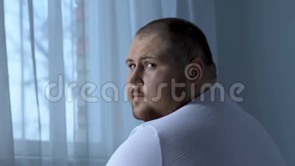 悲伤的肥胖男人绝望地看着镜头抑郁导致了健康问题视频的预览图